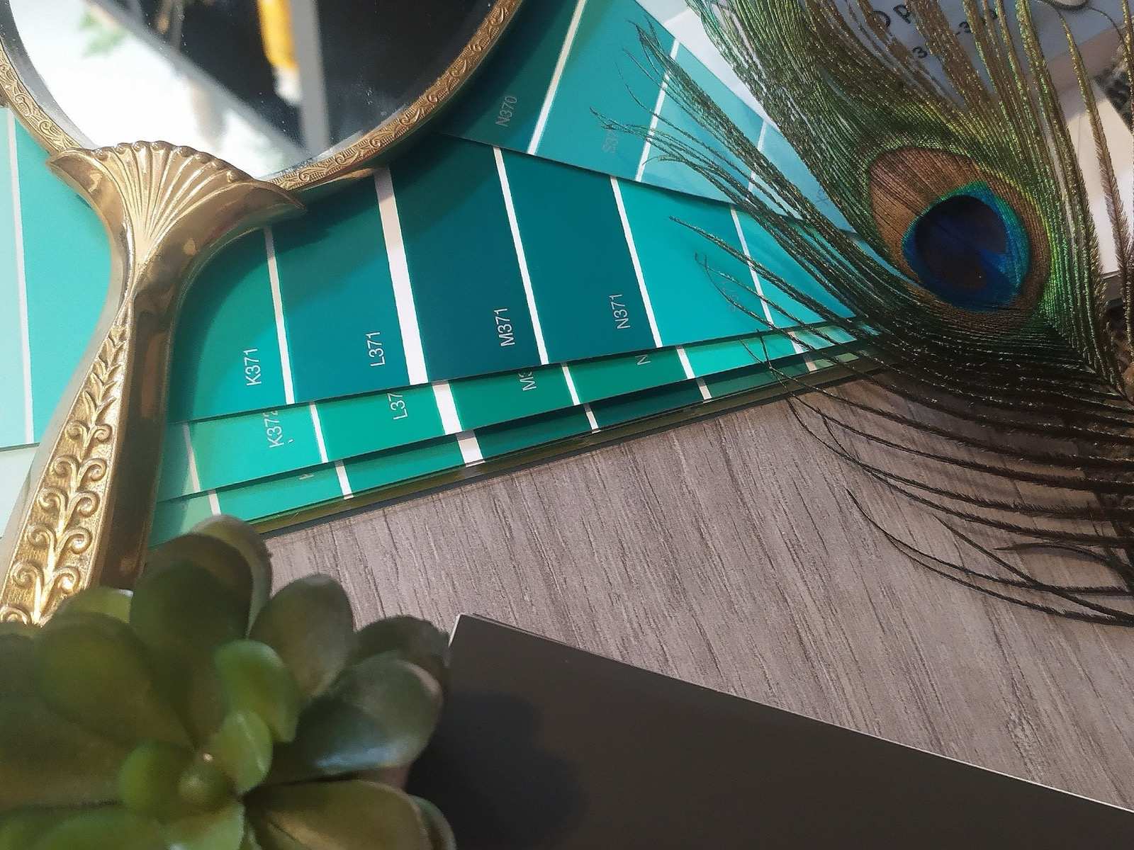Tikkurila-viuhkat, messinkipeili ja riikinkukonsulka sisustussuunnittelun flatlaykuvassa